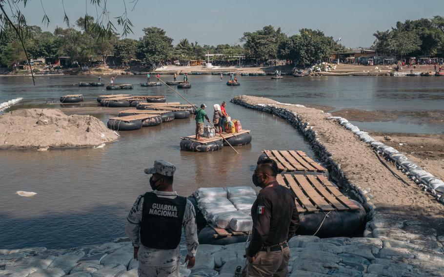 Officers wait to check the identification cards of migrants crossing the Suchiate River in Ciudad Hidalgo, Mexico, on Jan. 21, 2021. 