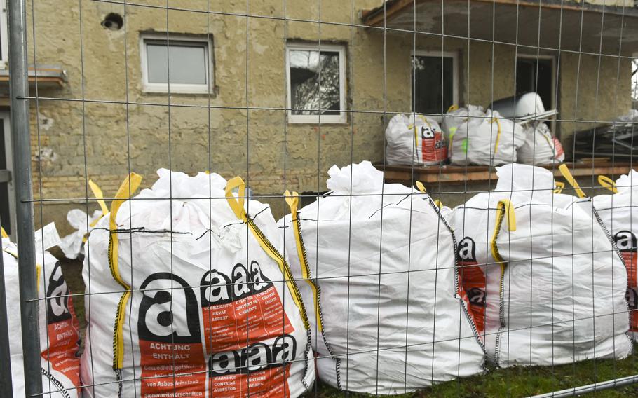 Construction waste bags marked with asbestos warnings are lined up in the demolition area in the Army's Crestview neighborhood March 11, 2024, in Wiesbaden, Germany. Seven residential buildings are being torn down to make way for parking lots.