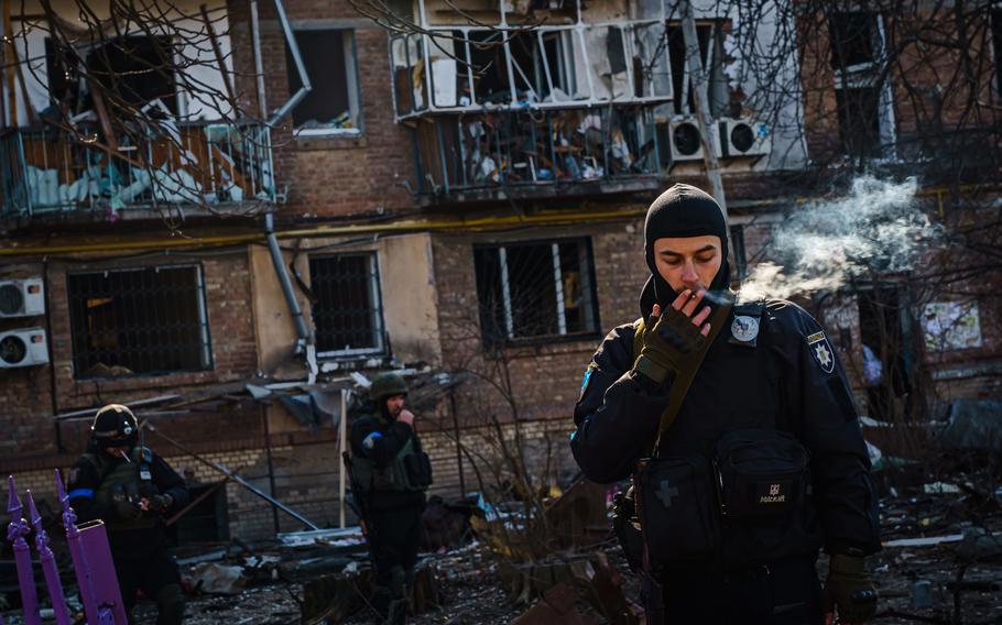 Police cordon off a perimeter around blast radius of a residential area damaged by what authorities say is a Russian bombardment, in Podilskyi district in Kyiv, Ukraine, on Friday, March 18, 2022.