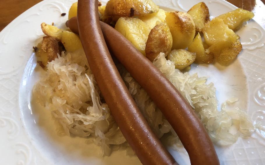 A pair of frankfurters served on sauerkraut and a side of fried potatoes at Zum Gemalten Haus in Frankfurt, Germany. To be called a Frankfurter wuerstchen in Germany, the thin, slightly smoked pork sausages must be made in Frankfurt and its surroundings.