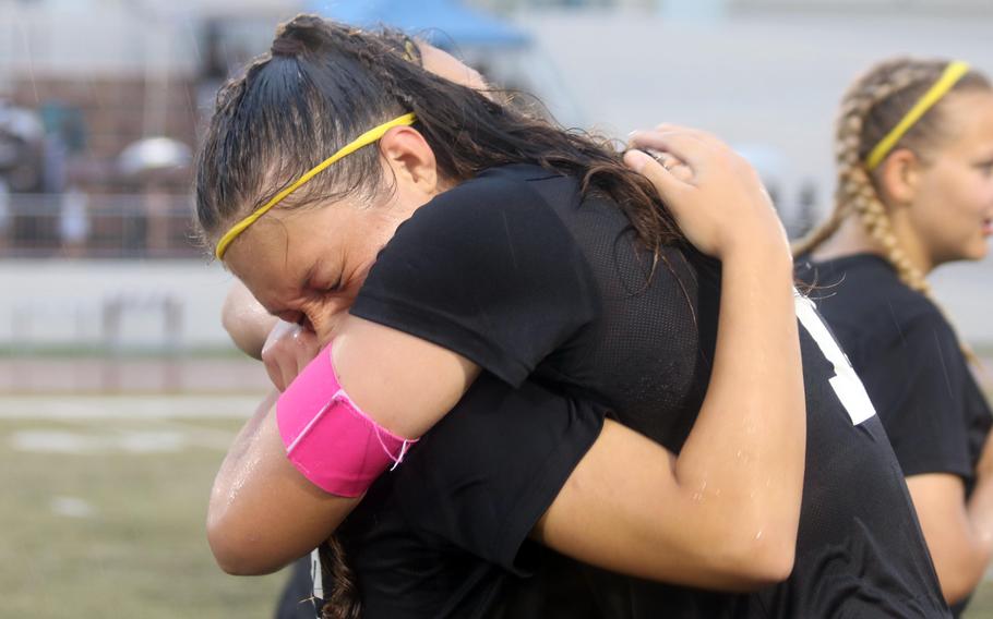 Perry's McKenzie Steele embraces fellow four-year Samurai teammate Sasha Malone seconds after ending their careers with a Far East Division II championshp banner.