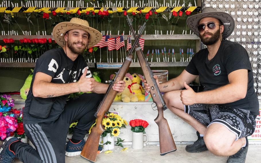 Sammy Botros, left, and Marcus Wirth run a shooting gallery attraction at the German-American Friendship Festival in Wiesbaden, Germany, on June 29, 2023. The festival is sponsored by the U.S. Army garrison in the city, and an estimated 70,000 people are expected to attend. 