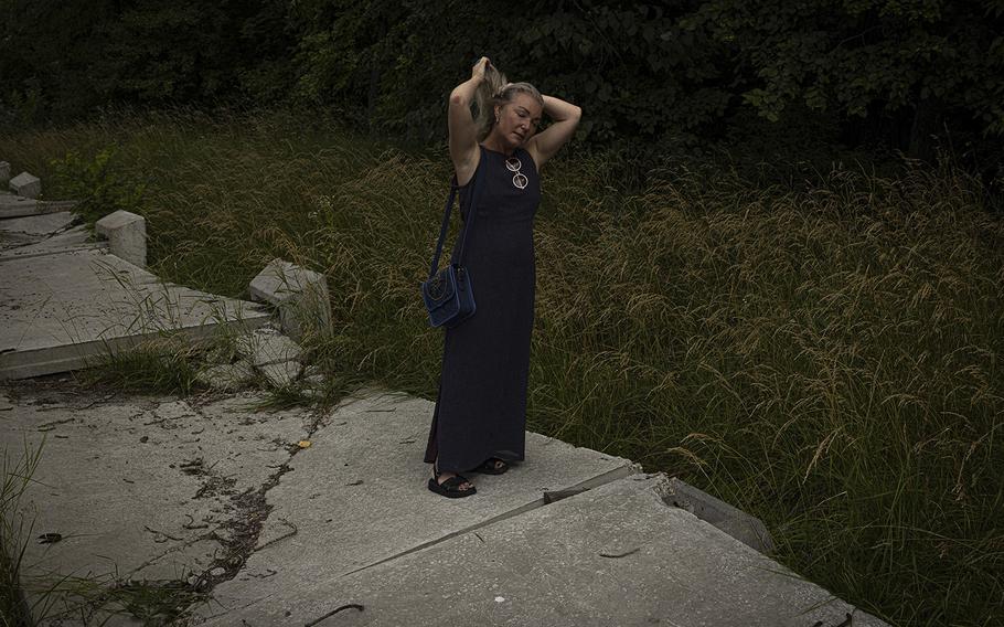 Svitlana Povalyaeva stands on a concrete fence that activists knocked down in Kyiv. 