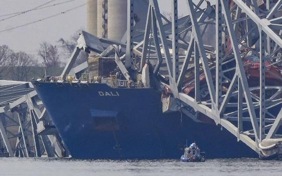 A container ship rests against wreckage of the Francis Scott Key Bridge on March 26, 2024, as seen from Sparrows Point, Md.