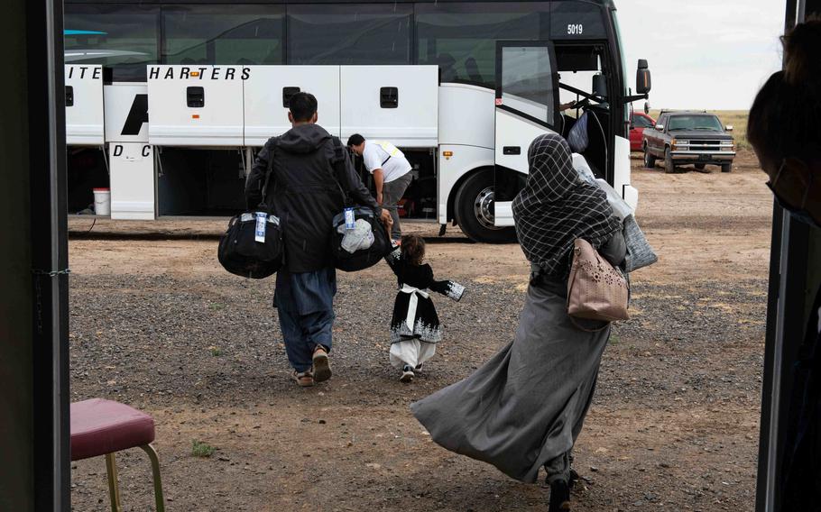 An Afghan family boards a bus at Holloman Air Force Base, N.M., on Sept. 28, 2021. A resettlement agency assists the evacuees with finding housing, searching for work and enrolling their children in schools.