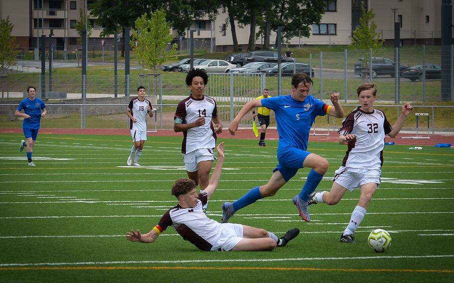 Ramstein Royals Team Captain and mid-fielder Benjamin Brewster jumps over a slide tackle by  Vilsecks Quinlan McKinney during the DODEA-Europe Soccer Championships at Ramstein Air Base, Germany, May 16, 2022. Vilseck could hold off the Royals for most of the game, but the Team found their rythm during the second half of the game for a 2-0 win.