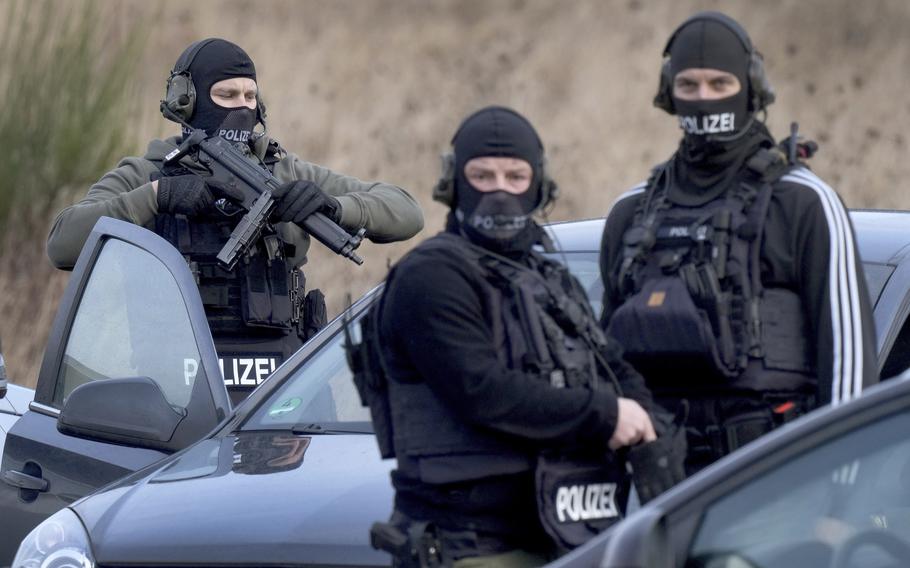 Police officers prepare for an operation close to a road where two police officers were shot during a traffic stop near Kusel, Germany, Monday, Jan. 31, 2022. 