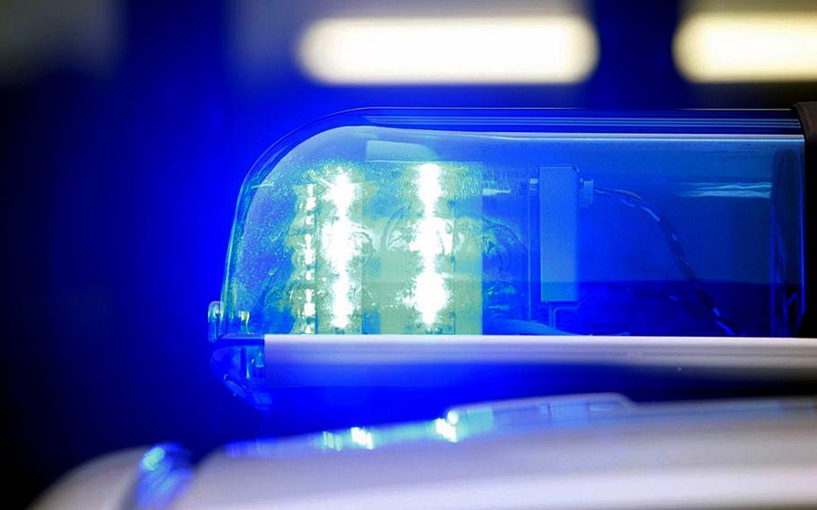 A police light casts a blue hue over a police car.