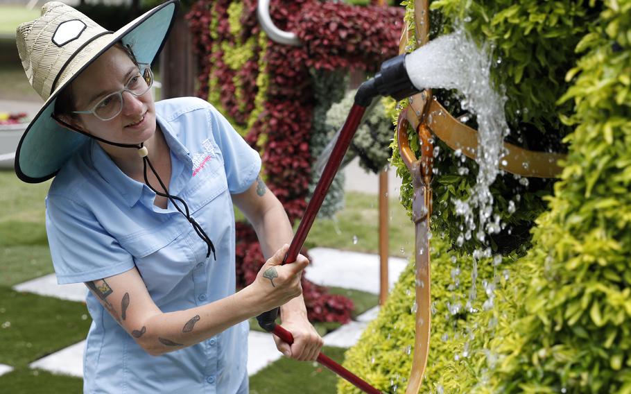 Marianne Spengler waters plants in the “Alice’s Adventures in the Garden” exhibit at Memphis Botanic Garden May 10 in Memphis, Tenn. The exhibit will remain open until Oct. 31. 