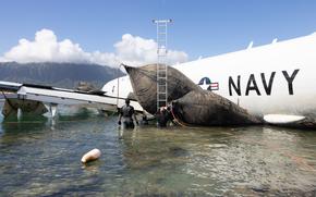 U.S. Navy Sailors with Company 1-2, Mobile Diving and Salvage Unit 1, inflate salvage roller bags to position a U.S. Navy P-8A Poseidon for extraction from waters off Marine Corps Air Station Kaneohe Bay, Marine Corps Base Hawaii, Dec. 2, 2023. Private industry diving and salvage experts as well as Sailors and Marines are actively working with local and off-island specialists to recover the structurally intact P-8A Poseidon; environmental protection measures are in place, including 24/7 monitoring, containment booms, absorbent material, and a skimmer on standby. (U.S. Marine Corps photo by Lance Cpl. Hunter Jones)