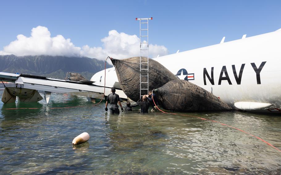 U.S. Navy Sailors with Company 1-2, Mobile Diving and Salvage Unit 1, inflate salvage roller bags to position a U.S. Navy P-8A Poseidon for extraction from waters off Marine Corps Air Station Kaneohe Bay, Marine Corps Base Hawaii, Dec. 2, 2023. 
