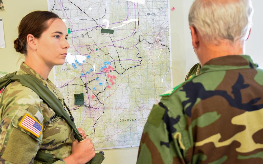 Staff Sgt. Emily Lamontagne, who serves in intelligence with the National Guard’s 54th Security Force Assistance Brigade, briefs a role player playing a partner force commander on the ongoing battle during a pre-deployment training exercise Aug. 23, 2023, at Muscatatuck Training Center in Indiana. Lamontagne’s unit will attach to the 1st Security Force Assistance Brigade this fall to deploy to Colombia.