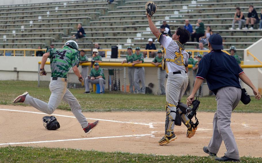 Kubasaki's Andrew Welte dashes home ahead of the throw to Kadena catcher Jeremiah Sprague during Wednesday's Okinawa baseball game. The Dragons won 8-5.