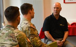 Army Emergency Relief Communications Chief Sean Ryan, right, speaks with soldiers at Rhine Ordnance Barracks in Kaiserslautern, Germany, Tuesday, Sept. 28, 2022, about the financial help AER offers troops.