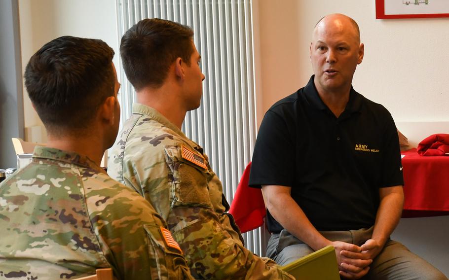 Army Emergency Relief Communications Chief Sean Ryan, right, speaks with soldiers at Rhine Ordnance Barracks in Kaiserslautern, Germany, Tuesday, Sept. 28, 2022, about the financial help AER offers troops. 