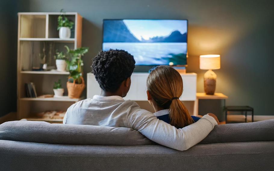 A young couple streaming a movie enjoying their weekend