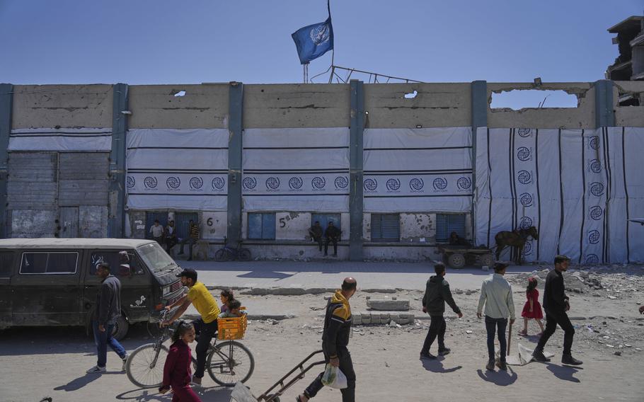 People walk across from a closed humanitarian aid distribution center of UNRWA.