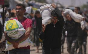 People carrying large bags of aid.