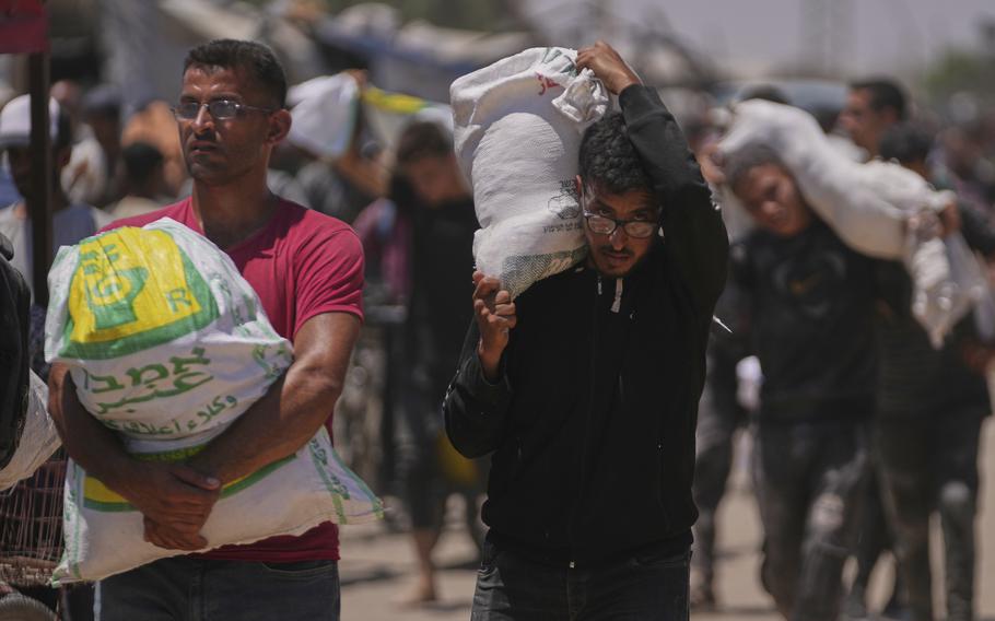 People carrying large bags of aid.