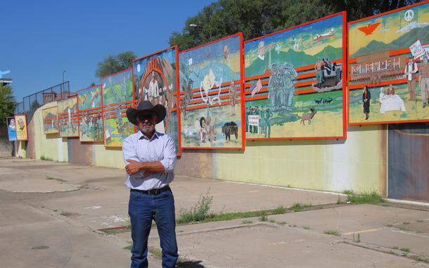 Rock Ulibarri stands in front of “The People’s History of El Norte,” an 11-panel chronology of Las Vegas mural he designed. It was then vividly painted by some 300 high school students. 