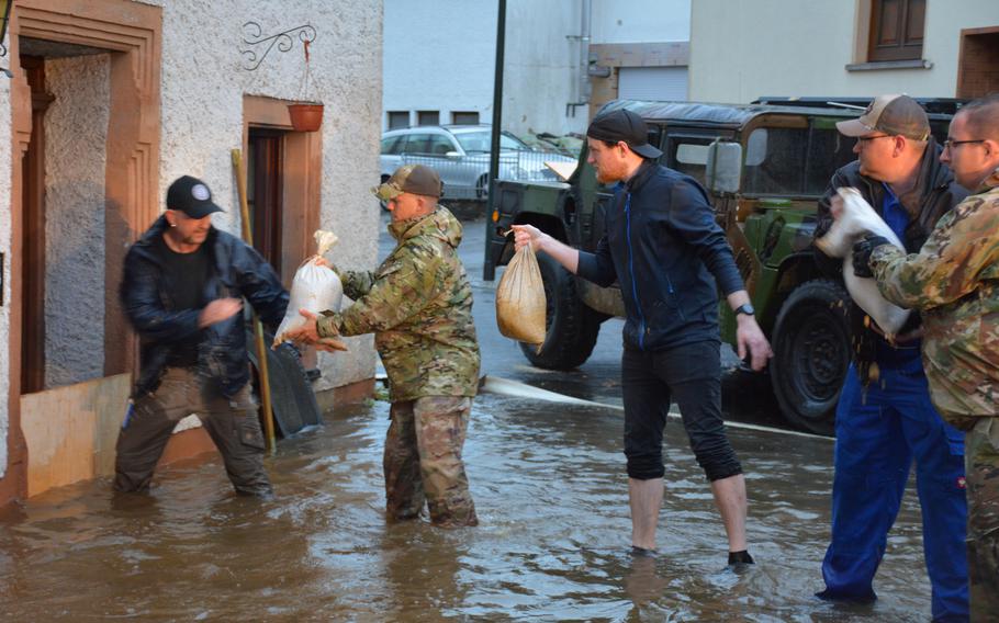 Members of Spangdahlem Air Base's 52nd Civil Engineering Squadron pass along sandbags with German first responders to prevent flooding in Binsfeld, Germany, July 14, 2021. 