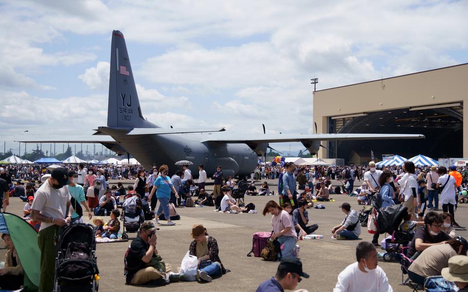 People relax near a C-130J Super Hercules during the Friendship Festival at Yokota Air Base, Japan, Sunday, May 22, 2022.