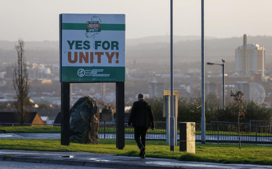 A pedestrian passes a sign that read “Yes For Unity!” placed by Sinn Fein in Belfast, Northern Ireland, on Jan. 3, 2020. 