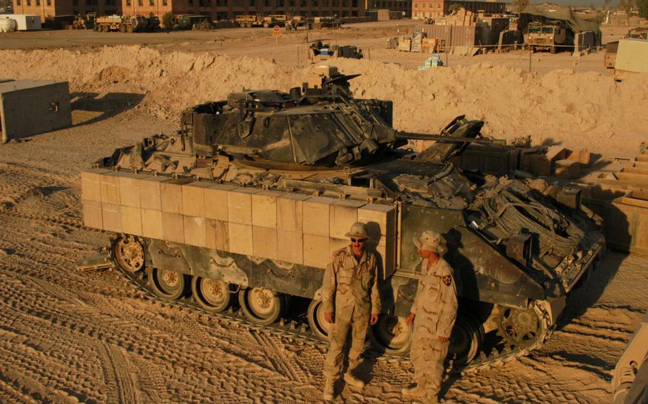 From left, 1st Battalion, 9th Infantry Regiment Manchus Sgt. John Eimers, 24, of Chicago, Ill., and Spc. Andrew Palmieri, 24, of San Diego, Calif., add armor to one of the unit’s Bradley fighting vehicles nicknamed “Myrth Mobile” in Iraq. 