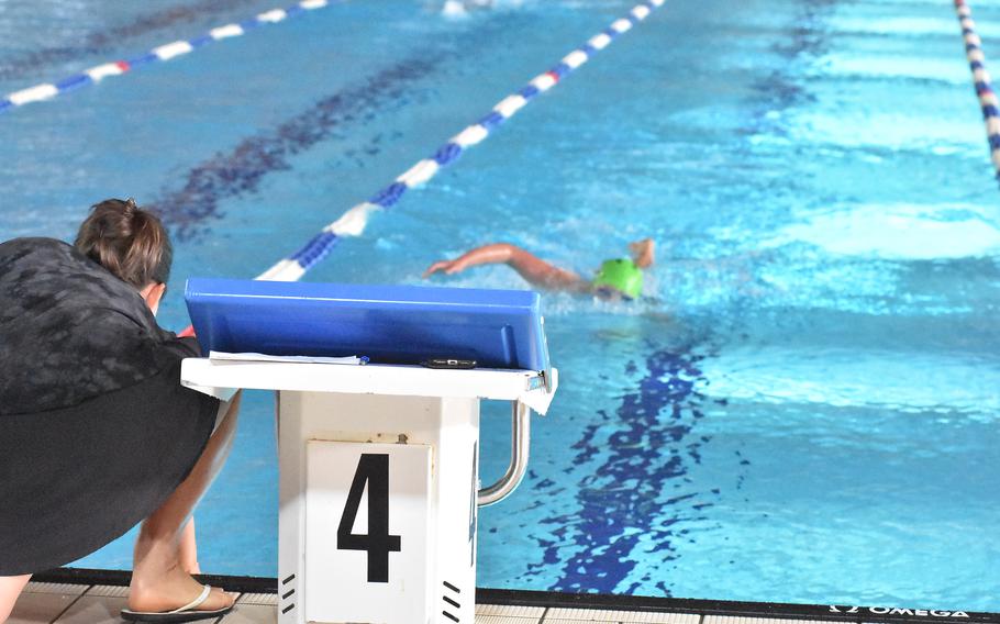 Shannon Buckley swims toward her mother Jamie, who holds an indicator telling her how many laps she has left in a heat of the girls 1,500-meter freestyle on Sunday, Nov. 27, 2022 at the European Forces Swim League Long Distance Championships in Lignano Sabbiadoro, Italy. Buckley set a new record and had the fastest time of any competitor in the event.