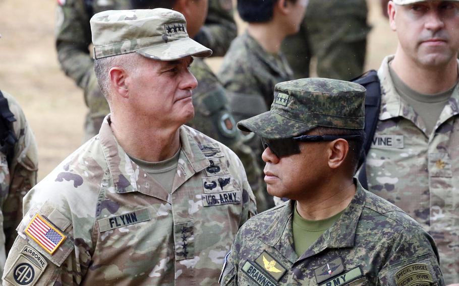 Gen. Charles Flynn, commander of U.S. Army Pacific, and Lt. Gen. Romeo Brawner, head of the Philippine army, observe a Balikatan drill at Fort Magsaysay, Philippines, Thursday, April 13, 2023.