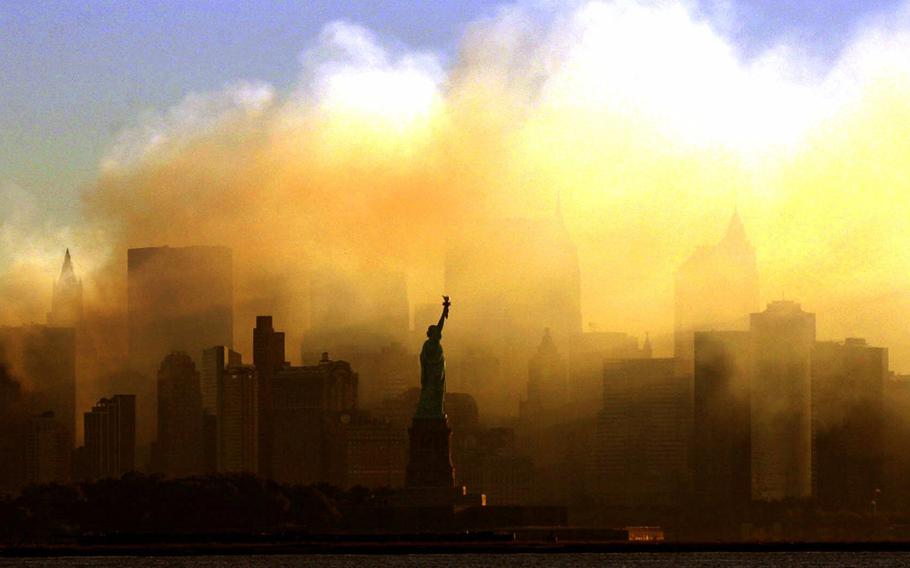 The Statue of Liberty stands in front of a smoldering lower Manhattan at dawn, seen from Jersey City, N.J., on Sept. 15, 2001 . The Sept. 11, 2001 terrorist attacks on the United States nearly 20 years ago precipitated profound changes in America and the world.