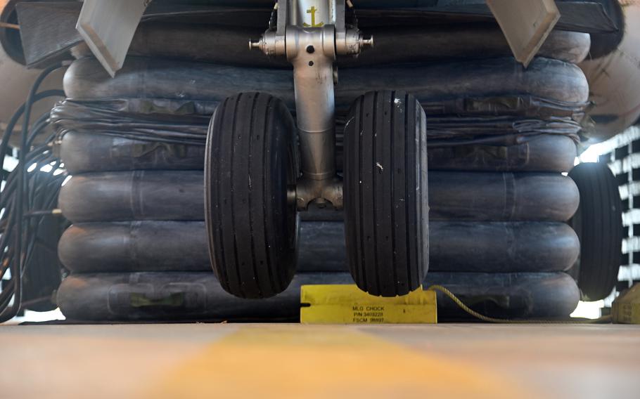 Close-up view of aircraft landing gear wheels and struts from below, showing dual wheels on the main landing gear. 