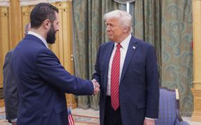 Trump and al-Sharaa shake hands.