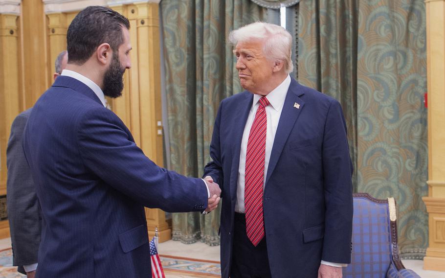Trump and al-Sharaa shake hands.