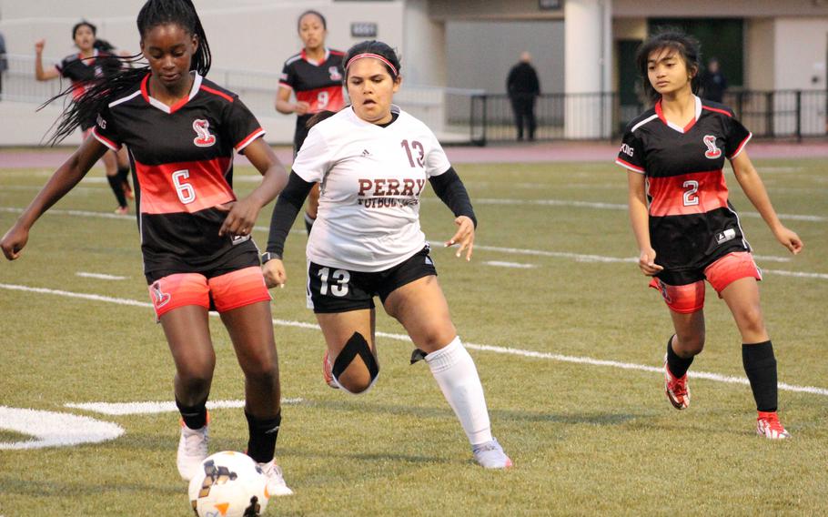 E.J. King’s Arianna Lemons dribbles the ball in front of Matthew C. Perry’s Maria Alverez during Friday’s DODEA-Japan soccer match. The Cobras won 8-1.