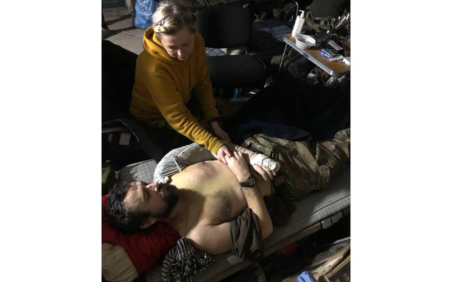 This recent but undated photo provided Friday, April 29, 2022 by the wife of a member of the Azov Regiment shows a woman comforting a wounded man inside the Azovstal steel plant, in Mariupol, eastern Ukraine.