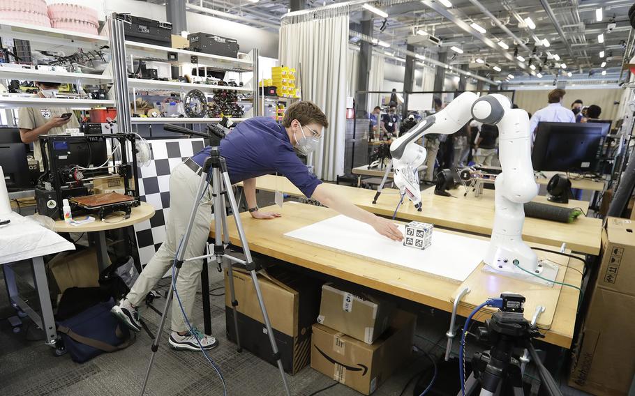 Penn Engineering PhD student in the Mechanical Engineering and Applied Mechanics Mathew Halm adjust blocks during a robot demonstration for the Building Dynamics Models through Contact Discontinuities during the Penn Engineering and Applied Sciences of General Robotics, Automation, Sensing and Perception Lab (GRASP) Technical Tours at the Pennovation Center on May 23, 2022.