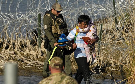 Migrants are taken into custody by officials at the Texas-Mexico border on Jan. 3, 2024, in Eagle Pass, Texas.