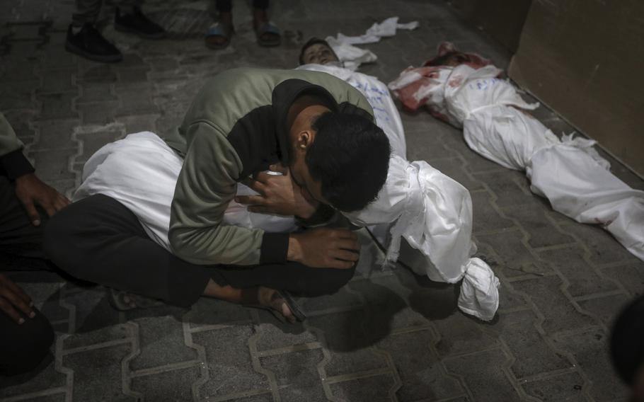 A Palestinian youth mourns his relative killed in the Israeli bombardment of the Gaza Strip, at the morgue of the Kuwaiti Hospital in Rafah refugee camp, southern Gaza Strip, early Saturday, April 20, 2024. 