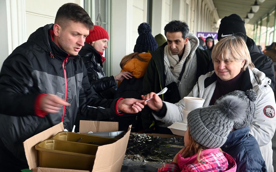 Volunteers feed refugees from Ukraine at the Przemysl, Poland, train station, March 2, 2022.