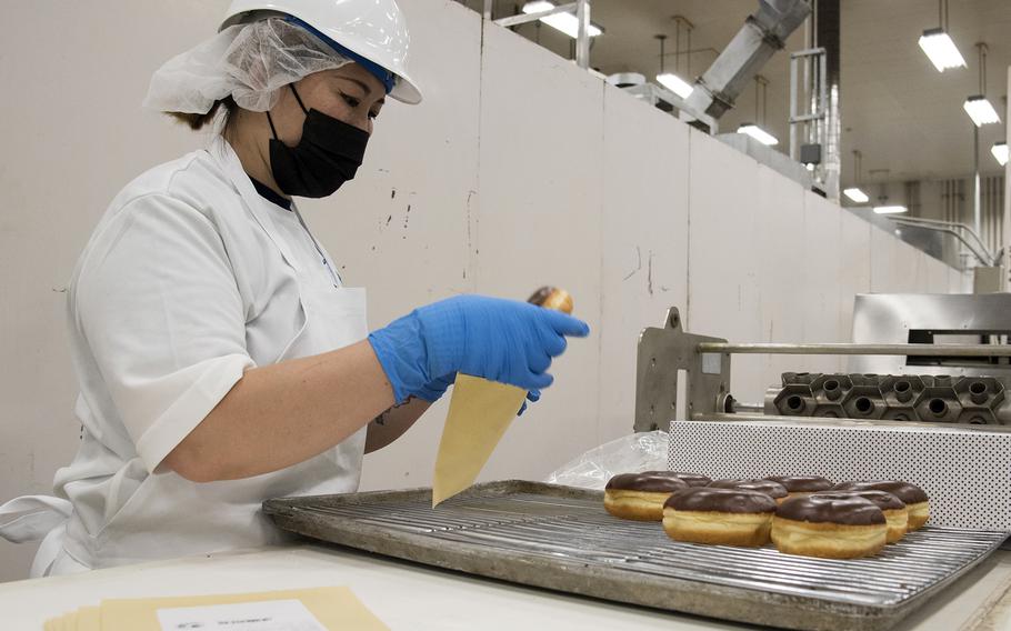 Fumiko Wilson packages doughnuts at the Yokota Bakery Plant on Yokota Air Base, Japan, Tuesday, April 19, 2022.