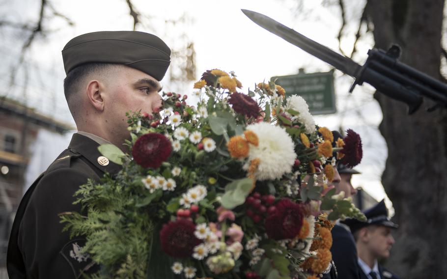 An American soldier wearing his service uniform carries a memorial wreath