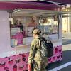 A servicemember stands outside a mobile food trailer.