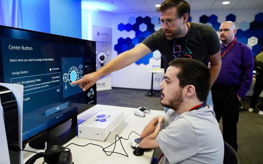 Martin Shane, right, customizes the button layout on the Sony Access controller before playing a video game at Sony Interactive Entertainment headquarters Sept. 28, 2023, in San Mateo, Calif.