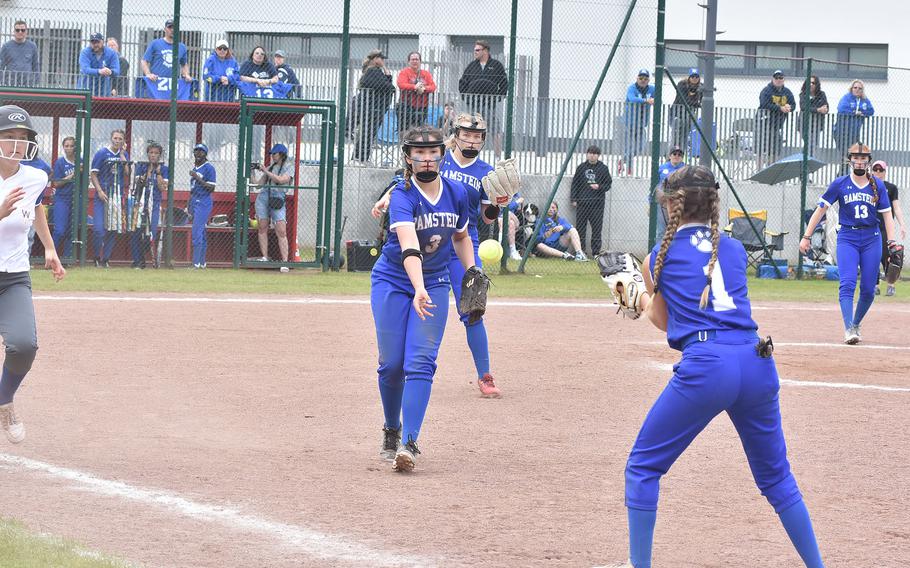 Ramsein first baseman Jazmyn Hall tosses the ball to second baseman Arianna Chambers while pitcher Madison Mihalic watches over her shoulder in the DODEA-Europe Division I softball championship game Saturday, May 20, 2023, at Kaiserslautern, Germany.
