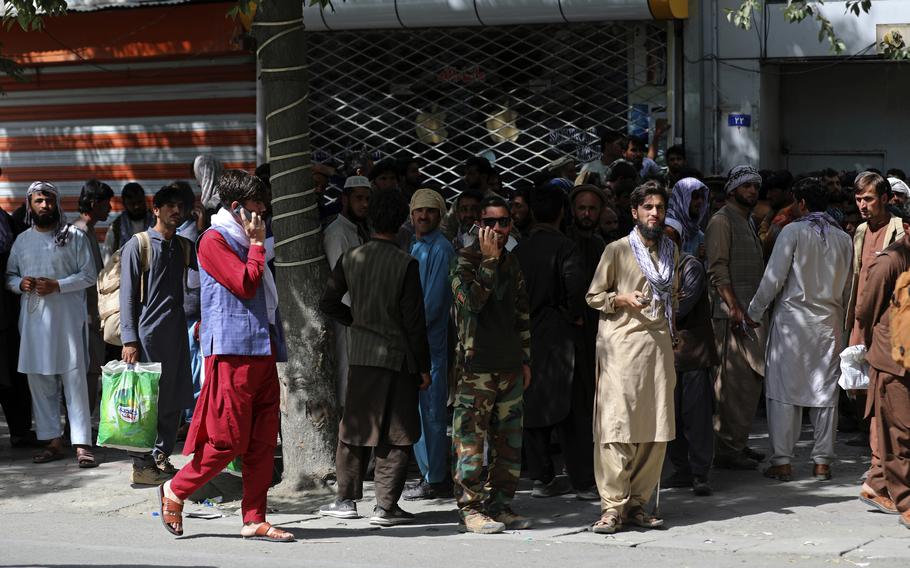 Afghans wait in long lines for hours to withdraw money, near Kabul Bank, in Kabul, Afghanistan, Sunday, Aug. 15, 2021.