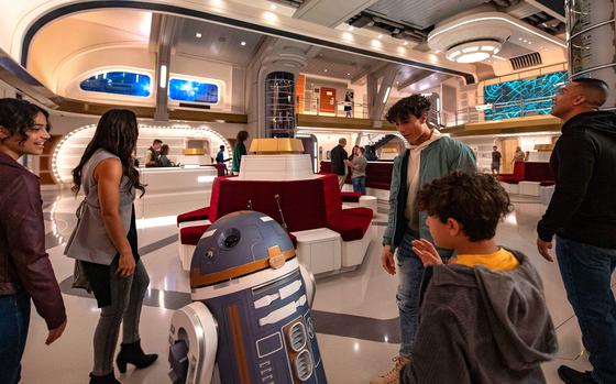 Guests are greeted by a droid in this promotional photo for the Star Wars: Galactic Starcruiser hotel at Walt Disney World in Florida. The hotel will close in the fall, less than two years after it opened. 