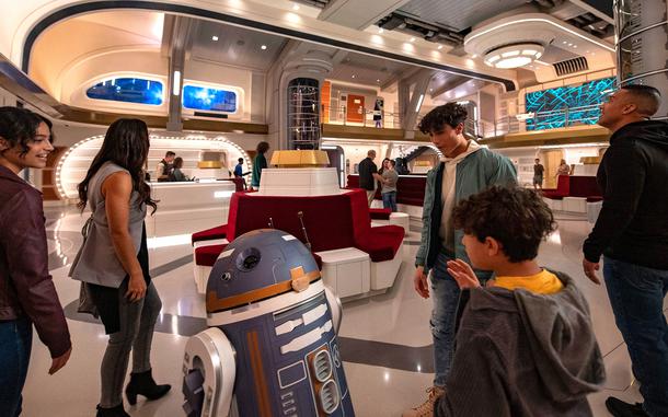 Guests are greeted by a droid in this promotional photo for the Star Wars: Galactic Starcruiser hotel at Walt Disney World in Florida. The hotel will close in the fall, less than two years after it opened. 