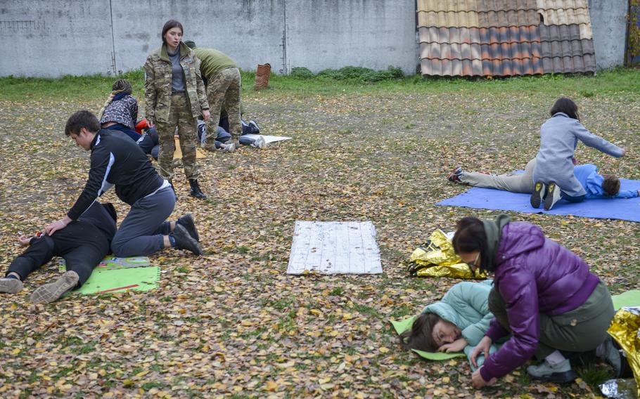 Nikoleta Dimitrulina instructs a class of Ukrainian civilians on combat first aid at a training site on the outskirts of Kyiv, Ukraine, on Oct. 27, 2022. Dimitrulina evaluated how her students placed casualties on their sides into the recovery position, which helps prevent unconscious patients from suffocating.