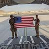 Staff Sgt. Duncan Copley, right, and another airman hold an American flag at the airport in Kabul, Afghanistan, during the evacuation of civilians from the country last year. Copley dealt with a bomb threat during one of his flights.